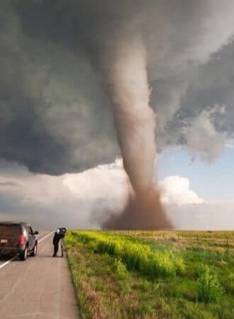 man taking photo of tornado